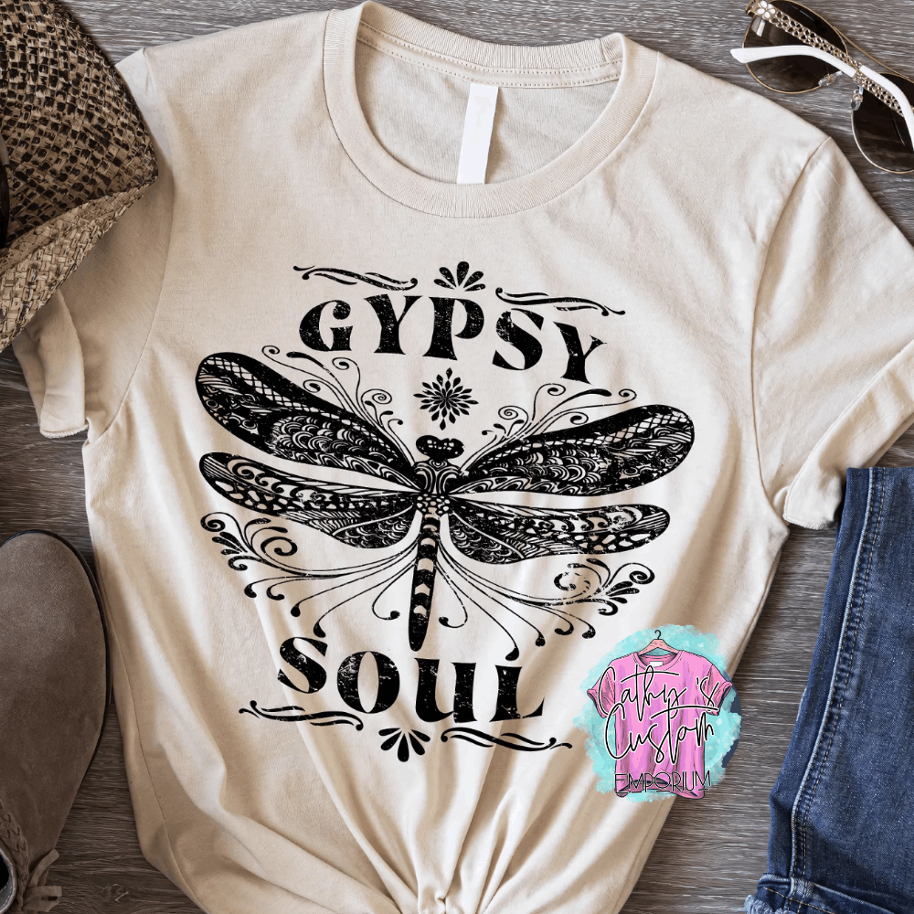 Beige T-shirt with "Gypsy Soul" printed in black, featuring an intricate dragonfly design with detailed boho-style patterns.