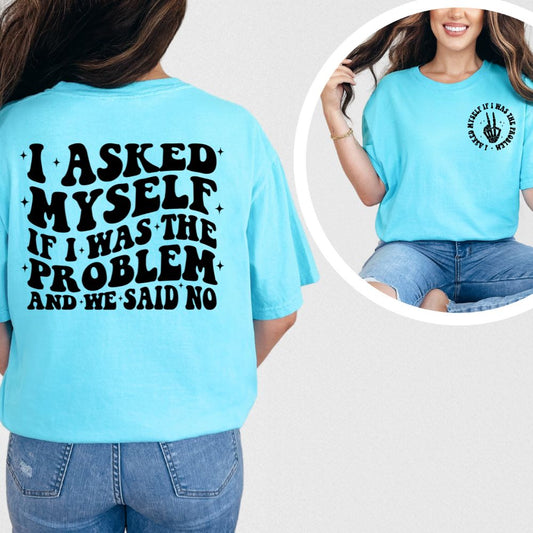 Bright blue t-shirt with bold black text on back reading “I Asked Myself If I Was the Problem and We Said No” and small matching front design.