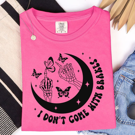Watermelon pink t-shirt with black crescent moon, skeleton hands, butterflies, and “I Don’t Come With Brakes” text.