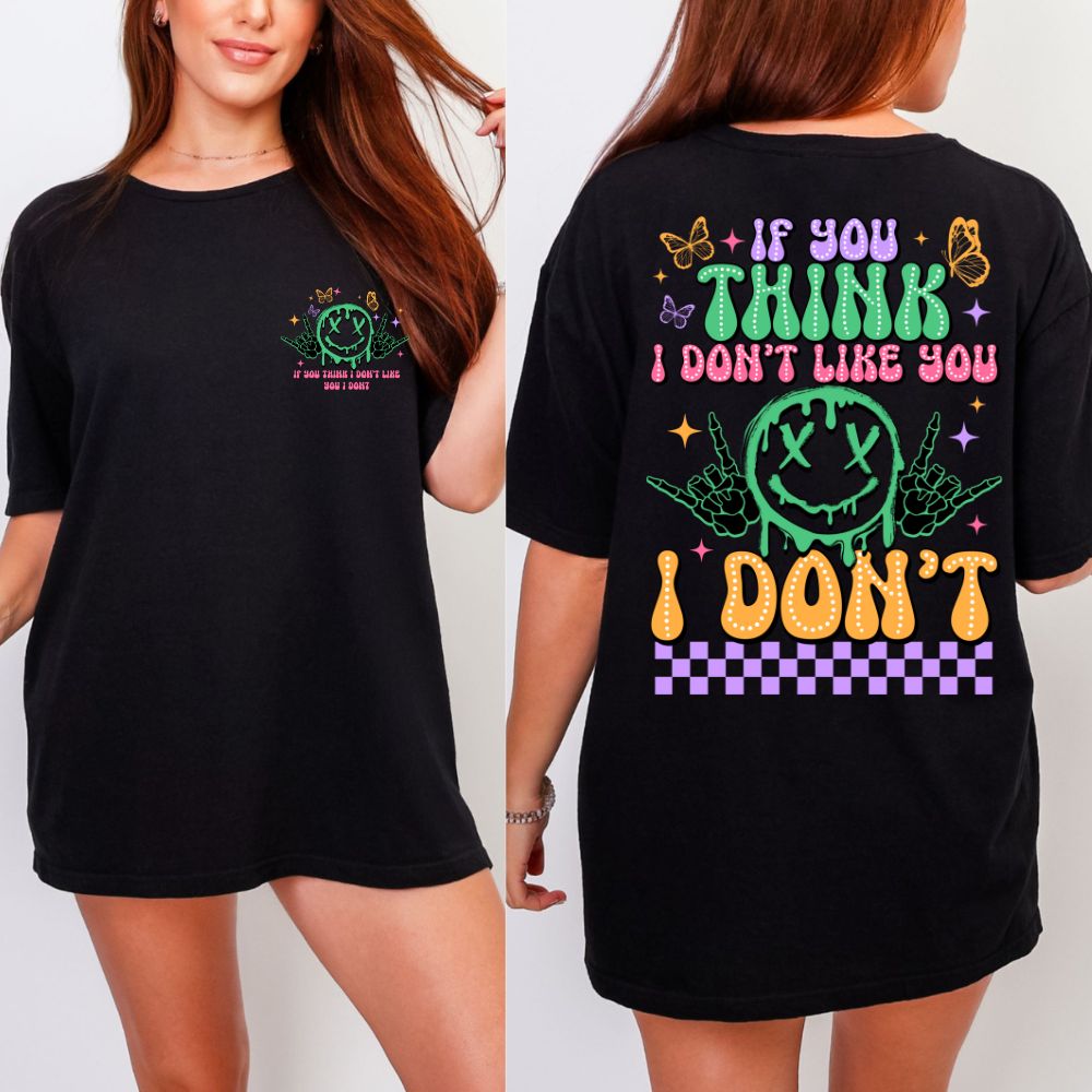 Black T-shirt with multicolor graphic saying “If you think I don’t like you… I don’t” with neon smiley and butterflies