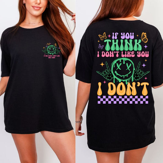 Black T-shirt with multicolor graphic saying “If you think I don’t like you… I don’t” with neon smiley and butterflies