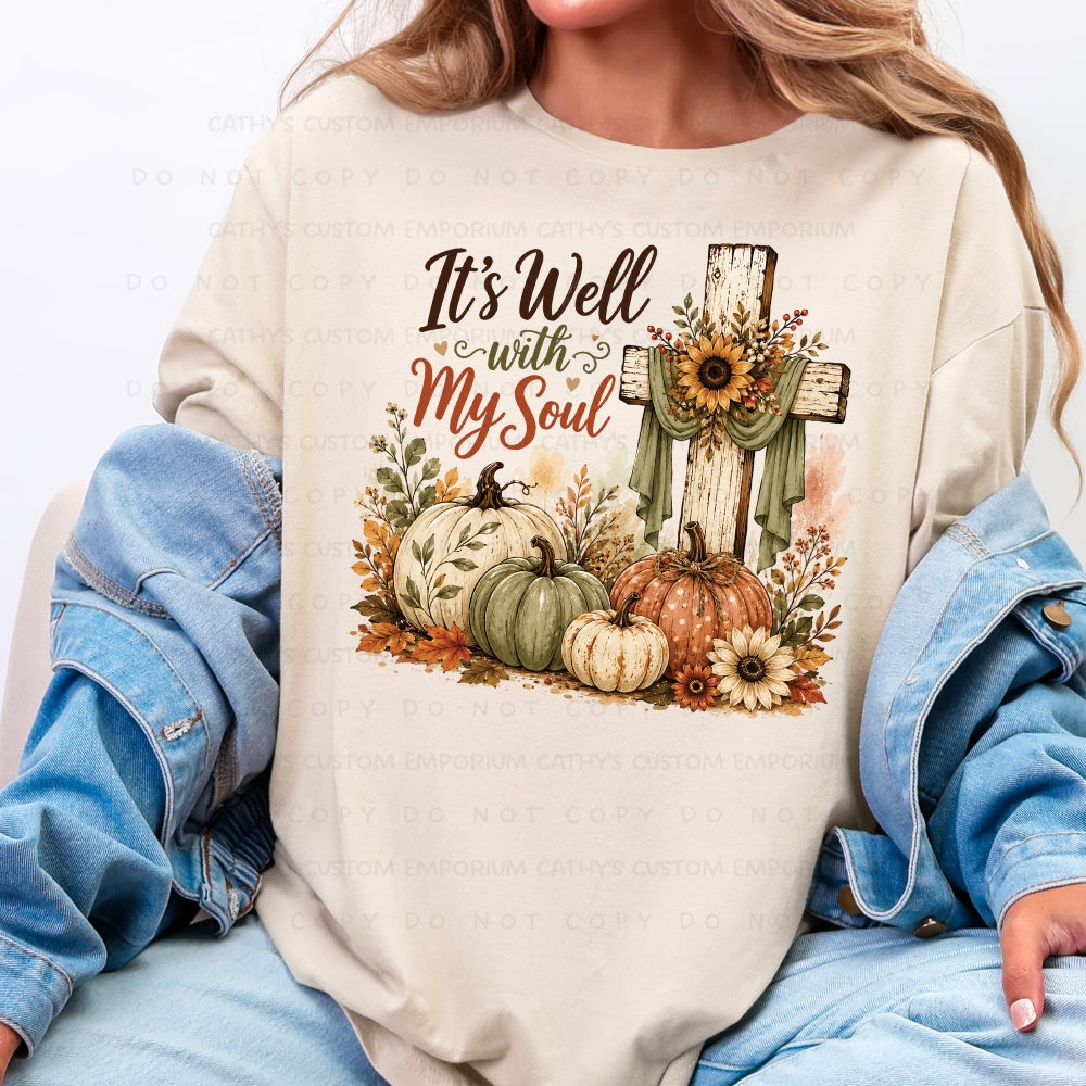 It’s Well With My Soul fall design with rustic cross, pumpkins, and sunflowers on Sand T-Shirt