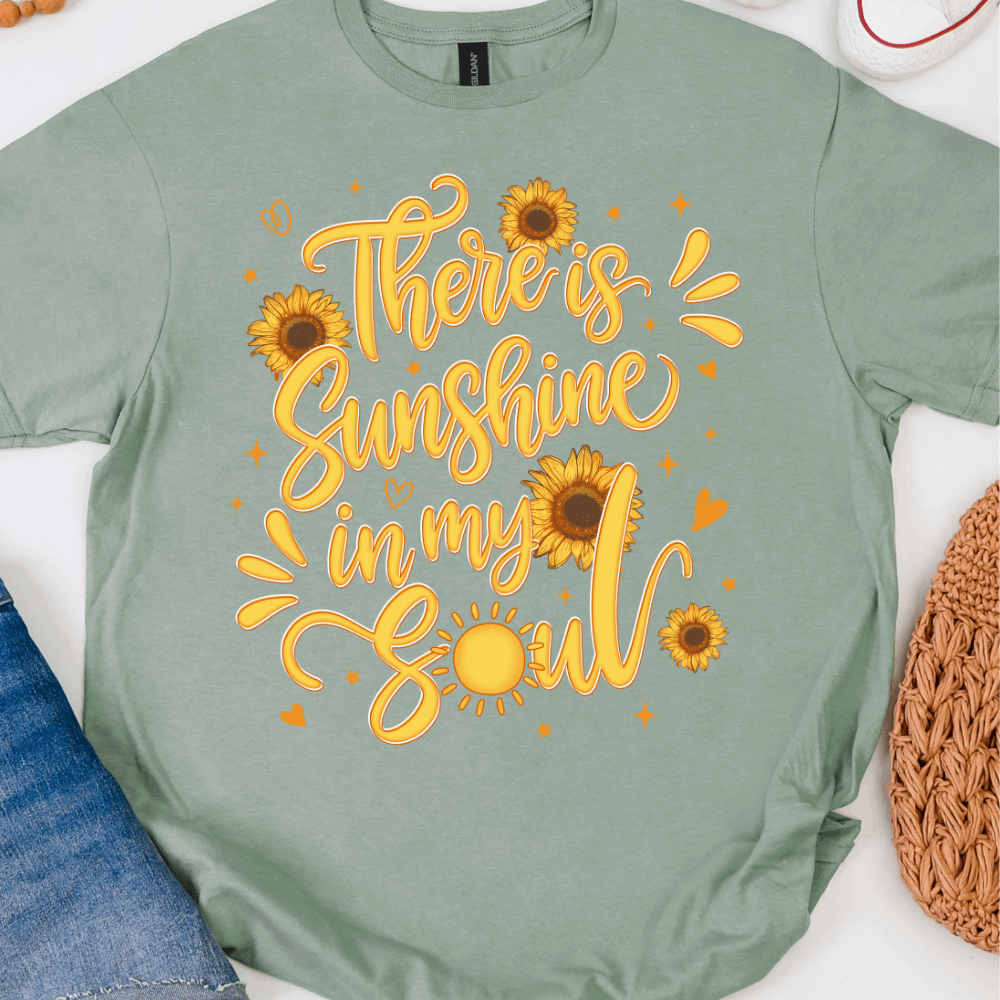 Sage green graphic T-shirt with There’s Sunshine In My Soul sunflower design