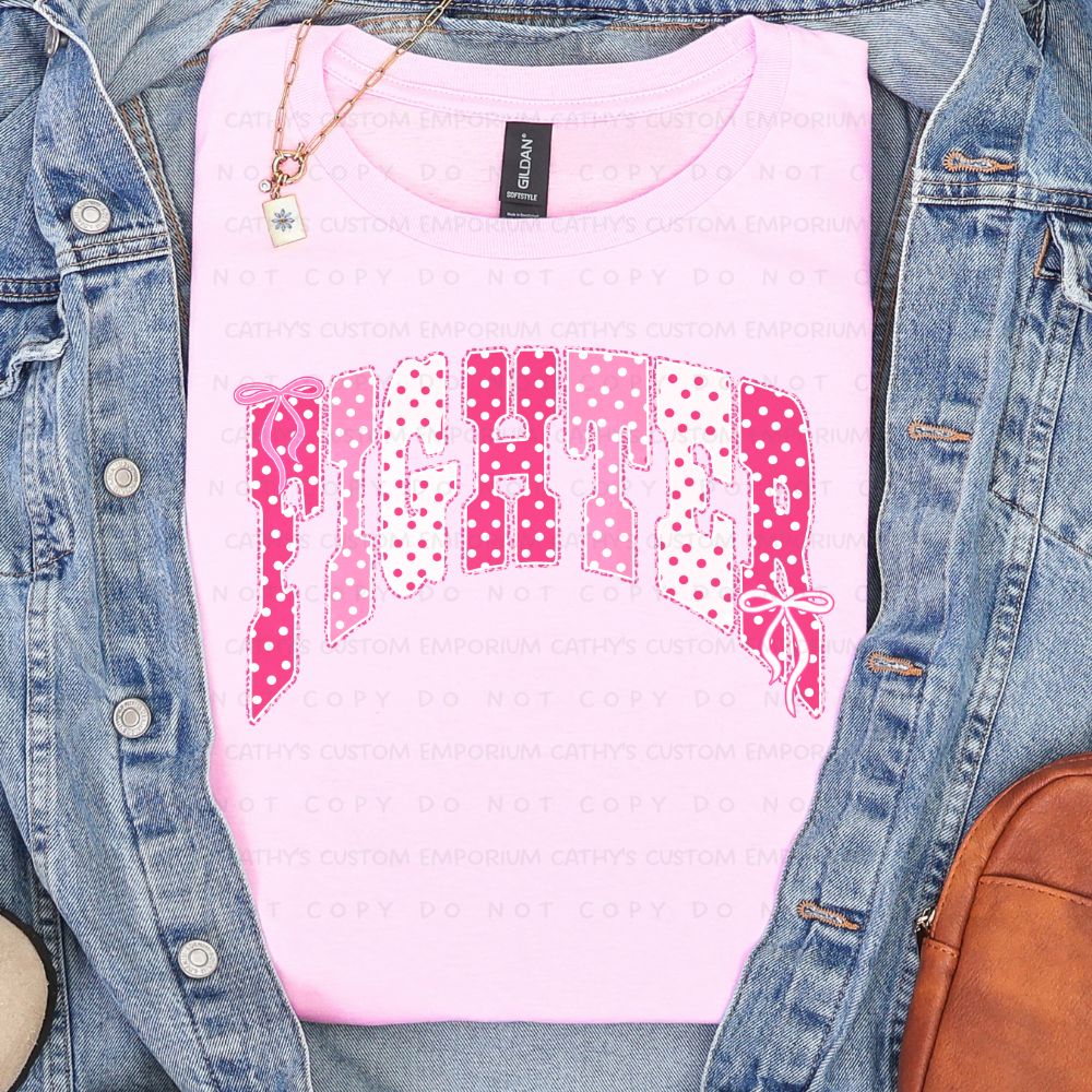 Light pink shirt featuring the word Fighter in pink and white polka-dot lettering with delicate bow accents for breast cancer awareness.