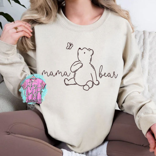 Mama Bear Graphic Sweatshirt in a soft neutral color, featuring a minimalistic bear and butterfly design with cursive 'Mama Bear' text. Cozy unisex crewneck for stylish comfort.