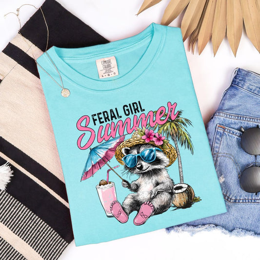 Aqua blue t-shirt with a graphic raccoon in sunglasses under “Feral Girl Summer.”

