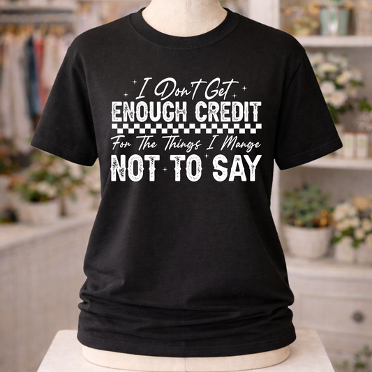 Black unisex graphic T-Shirt with “I Don’t Get Enough Credit For The Things I Manage Not To Say” design in distressed white lettering.