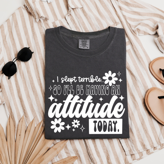 I Slept Terrible So I'll Be Having An Attitude Today graphic t-shirt shown on a Comfort Colors Pepper shirt in white print.