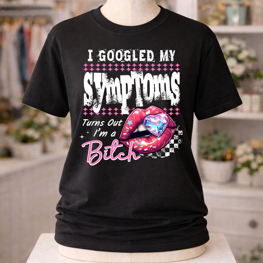 Black unisex graphic T-shirt with “I Googled My Symptoms Turns Out I’m a Bitch” design featuring distressed lettering and colorful pop-art lips with heart detail.