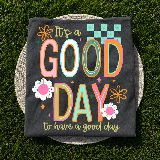 It's a Good Day to Have a Good Day graphic apparel on Comfort Colors Pepper featuring colorful retro lettering and floral accents.