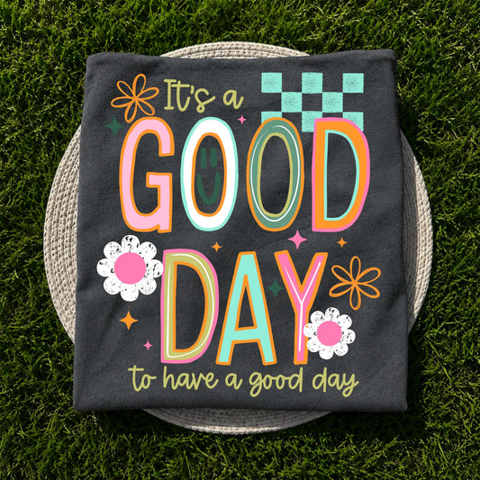 It's a Good Day to Have a Good Day graphic apparel on Comfort Colors Pepper featuring colorful retro lettering and floral accents.