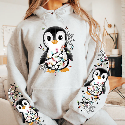 White hoodie with penguin design featuring lights and snowflakes. 