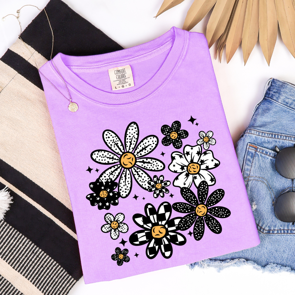 Retro Pattern Flower graphic t-shirt displayed on a Comfort Colors Orchid shirt featuring black and white patterned flowers.