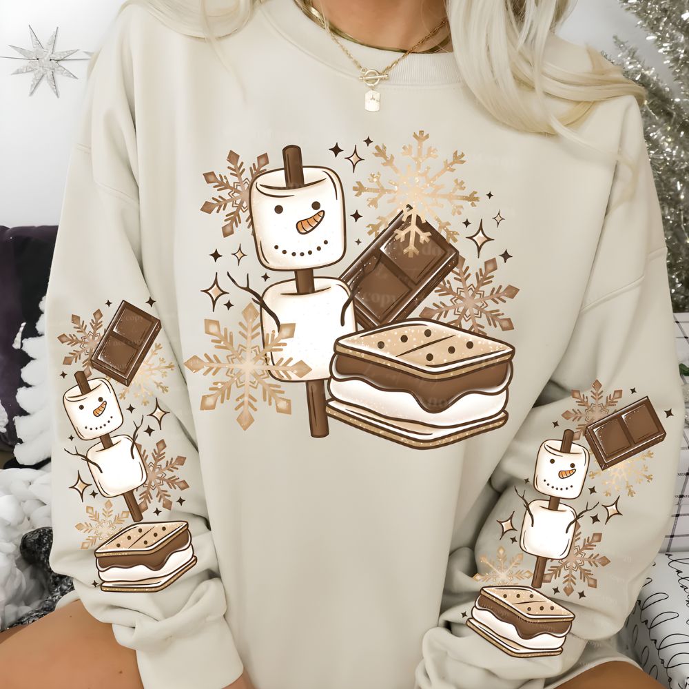 Beige sweatshirt with cute marshmallow snowman and s’mores winter-themed graphic on front and sleeves.
