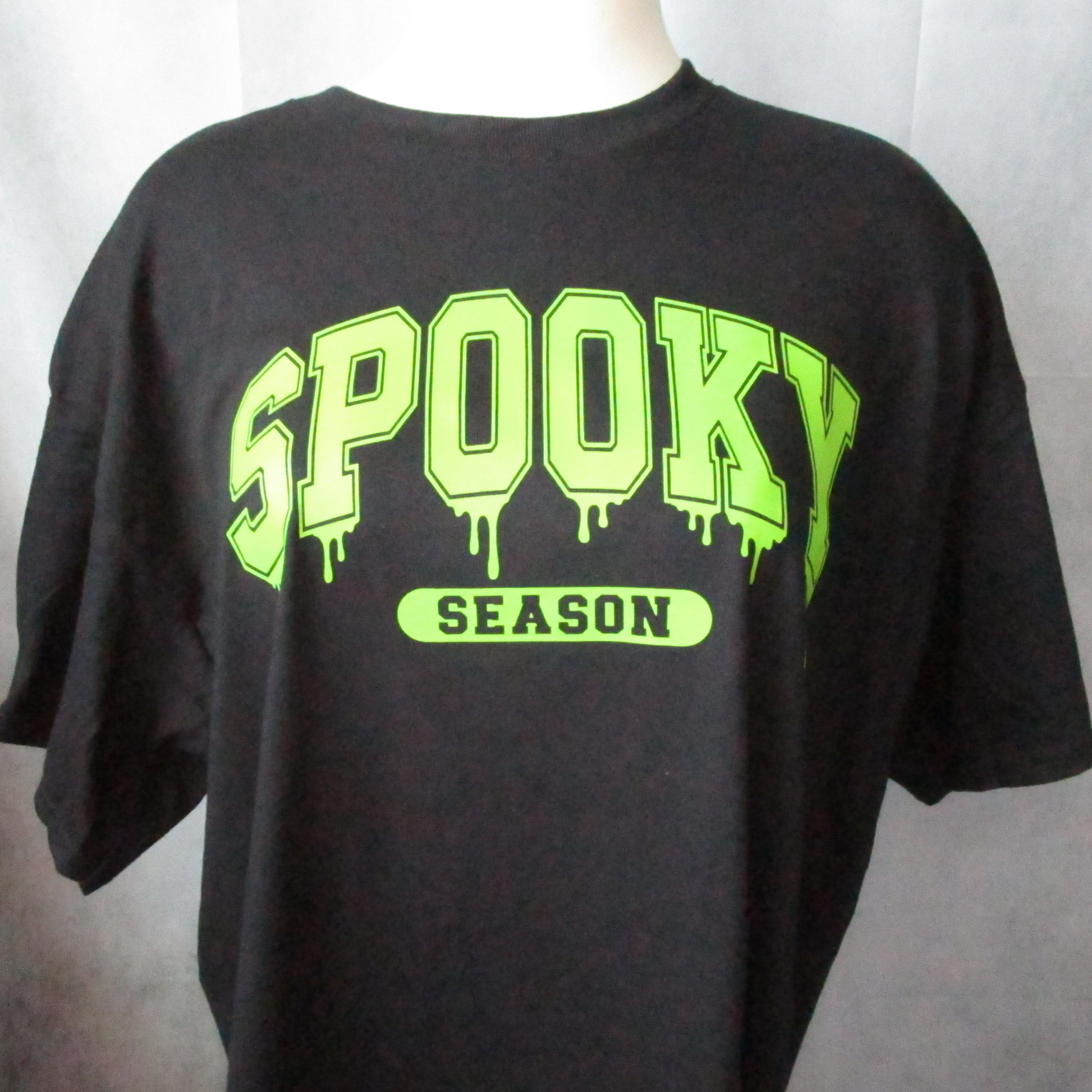 Oversized Spooky Season in Lime Green ink on a black t-shirt