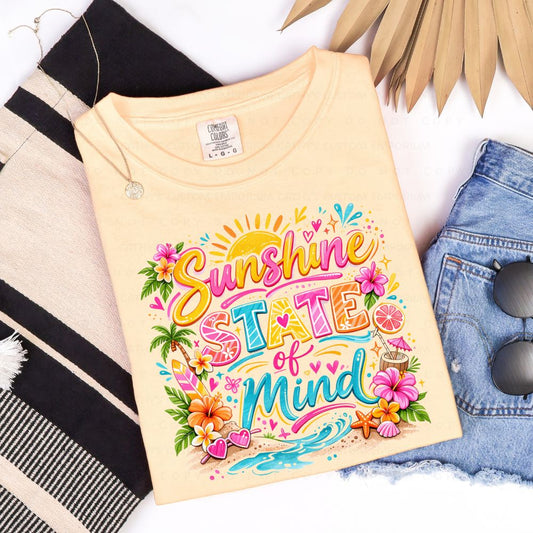 Comfort Colors Butter t-shirt with colorful 'Sunshine State of Mind' design on a white background with accessories.