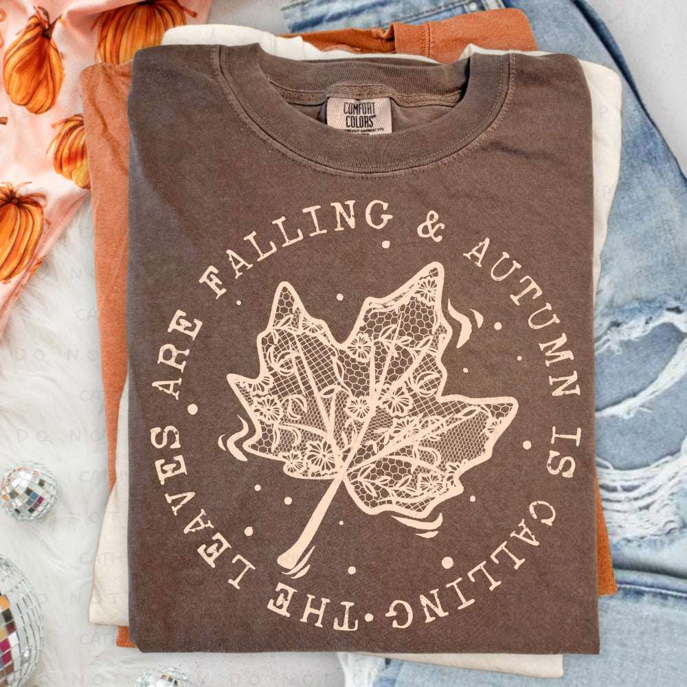 The Leaves Are Falling & Autumn Is Calling graphic T-shirt featuring a detailed autumn leaf design on a Comfort Colors Espresso shirt.
