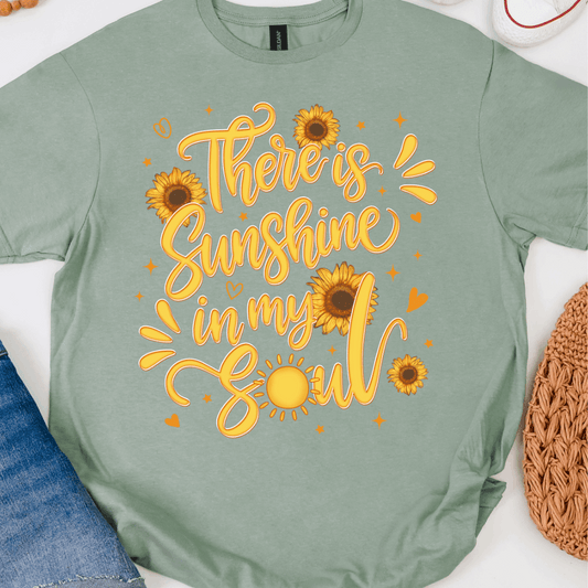 Sage green graphic T-shirt with There’s Sunshine In My Soul sunflower design