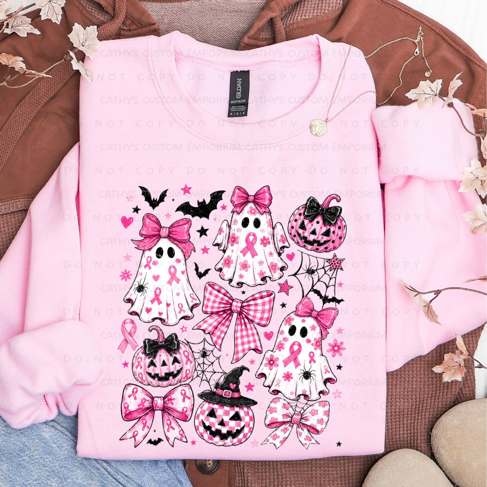 Light pink sweatshirt featuring pink-ribbon ghosts, jack-o-lanterns, bows, bats, flowers, hearts, and spiderwebs in a breast cancer awareness Halloween design.