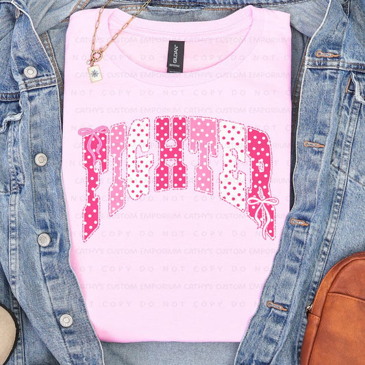 Light pink shirt featuring the word Fighter in pink and white polka-dot lettering with delicate bow accents for breast cancer awareness.