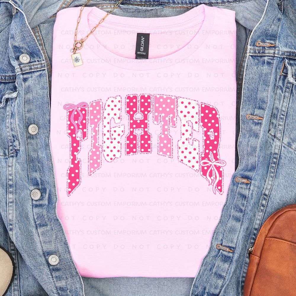 Light pink shirt featuring the word Fighter in pink and white polka-dot lettering with delicate bow accents for breast cancer awareness.
