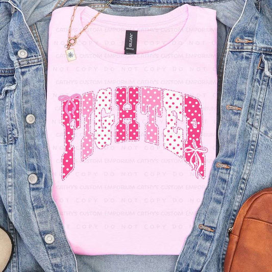 Light pink shirt featuring the word Fighter in pink and white polka-dot lettering with delicate bow accents for breast cancer awareness.
