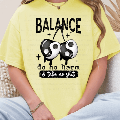 yellow graphic T-shirt with balance do no harm take no shit design with yin yang cherries