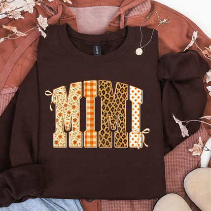 Brown sweatshirt featuring MIMI in floral, orange plaid, leopard print, and polka dot fall patterns
