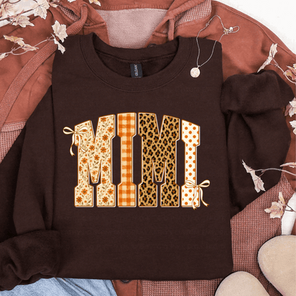 Brown sweatshirt featuring MIMI in floral, orange plaid, leopard print, and polka dot fall patterns