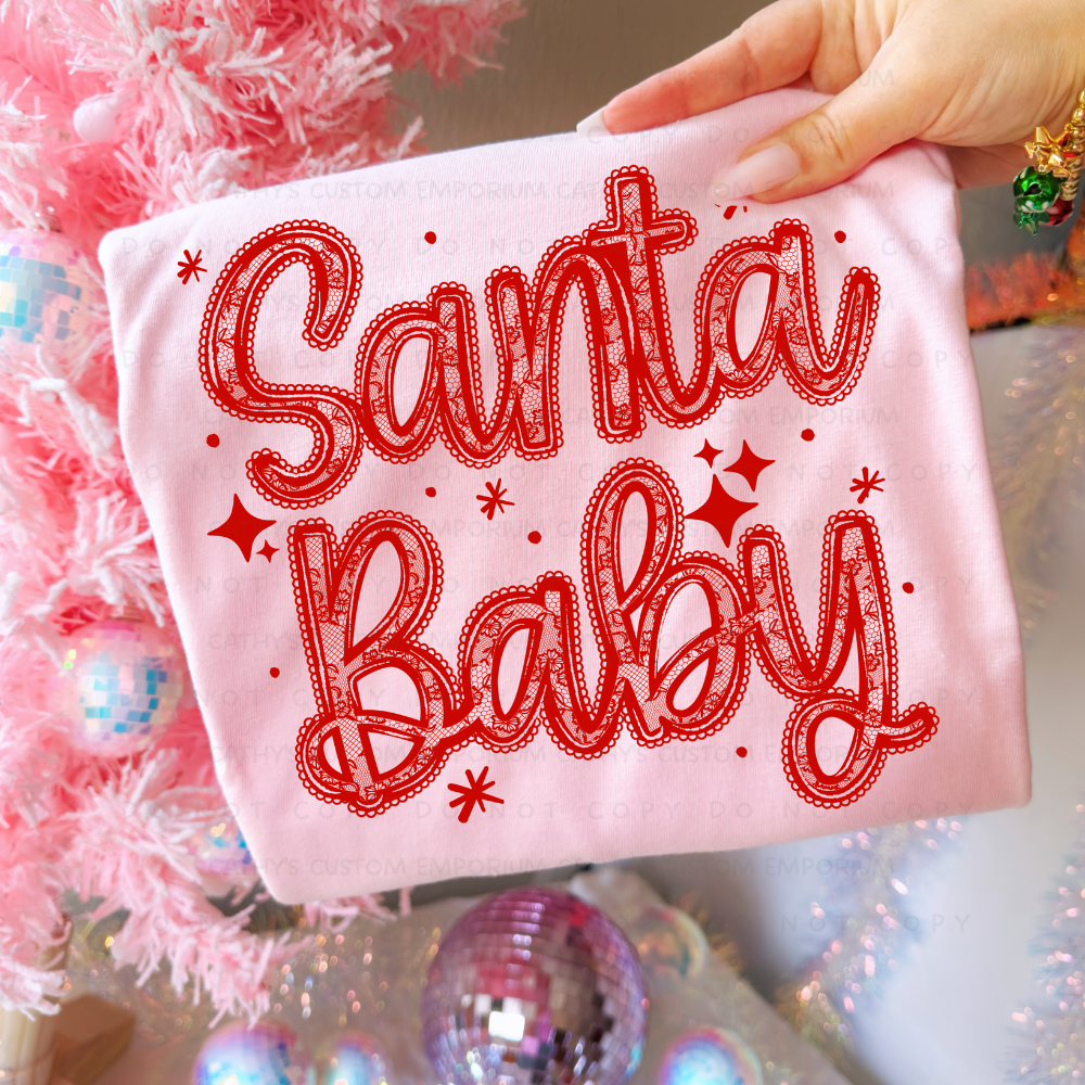 Red lace Santa Baby Christmas graphic shown on a light pink garment