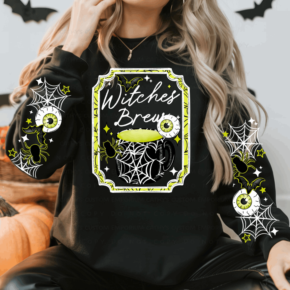 Woman wearing a black Witches Brew Halloween sweatshirt with a lime green cauldron, eyeballs, bats, spiders, webs, and coordinating sleeve designs